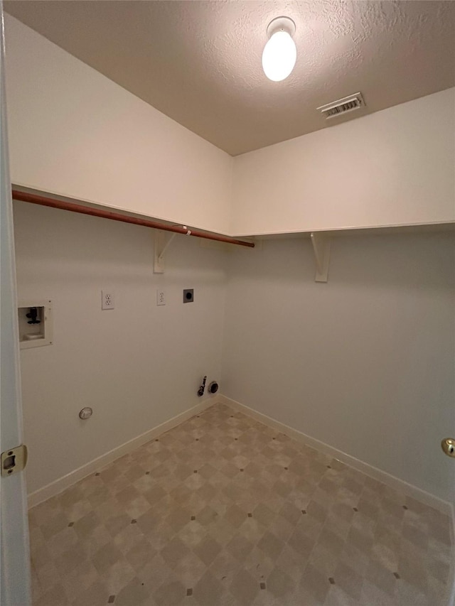 washroom featuring gas dryer hookup, washer hookup, a textured ceiling, and electric dryer hookup