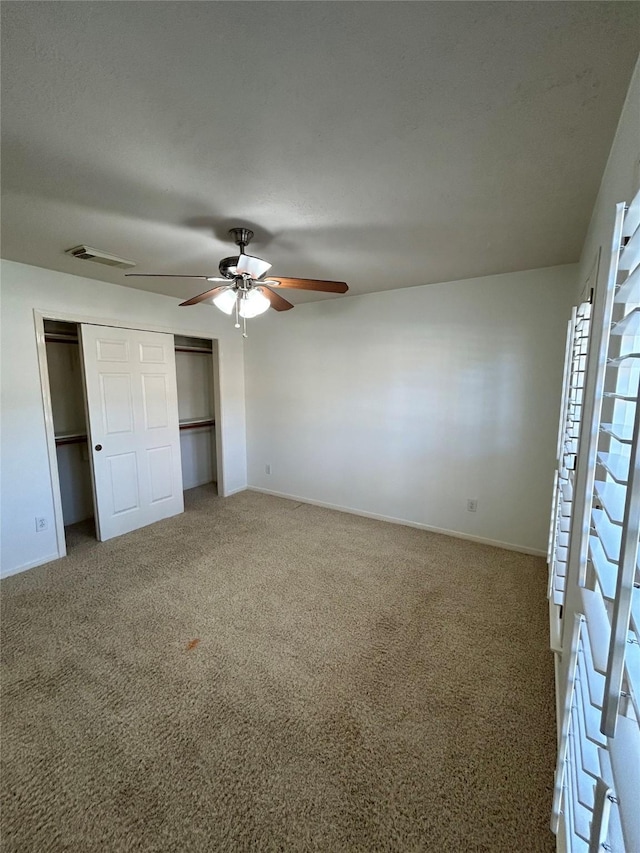 unfurnished bedroom featuring a closet, ceiling fan, and carpet flooring