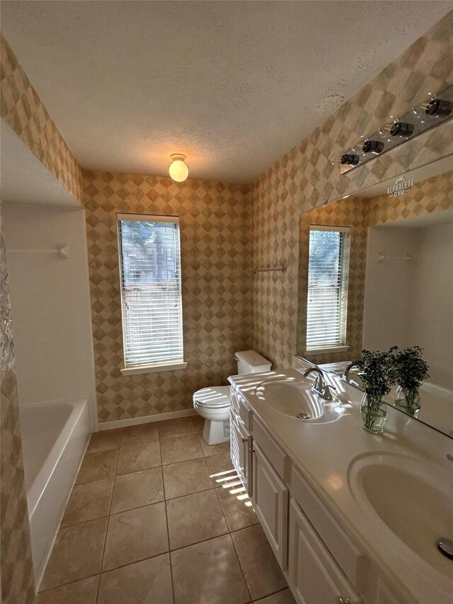 bathroom featuring vanity, tile patterned floors, a textured ceiling, and toilet