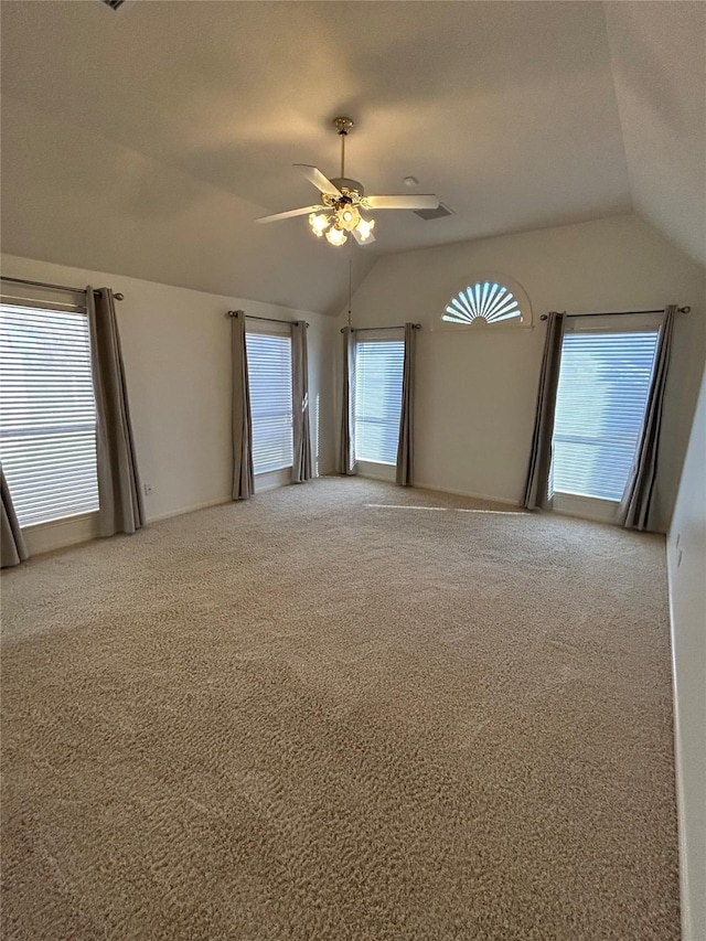 carpeted spare room featuring ceiling fan and vaulted ceiling