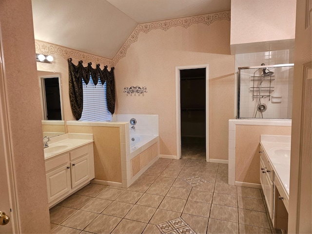 bathroom with tile patterned floors, separate shower and tub, vaulted ceiling, and vanity