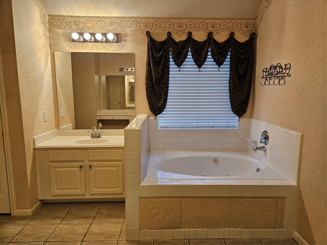 bathroom with tile patterned floors, vanity, and tiled tub