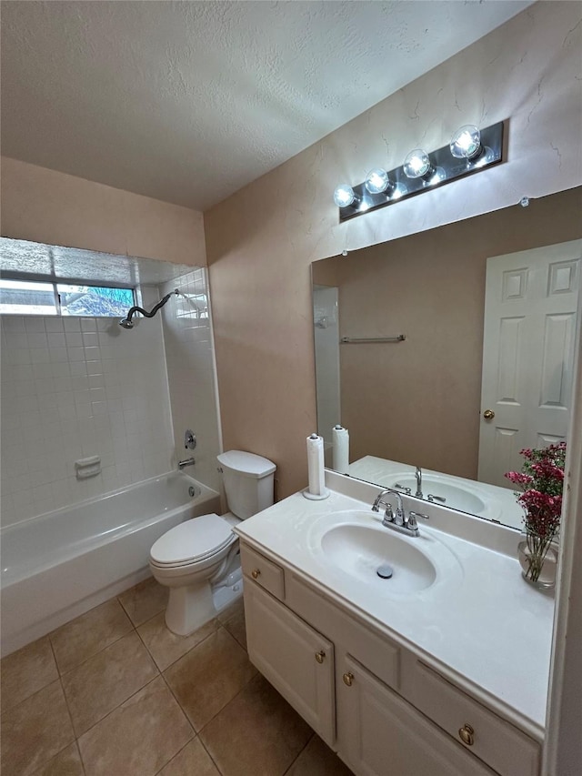 full bathroom with tile patterned flooring, vanity, a textured ceiling, tiled shower / bath, and toilet