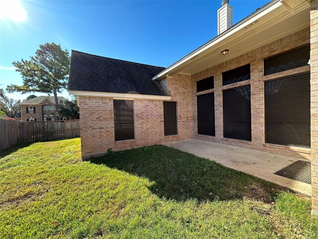 rear view of property featuring a yard and a patio area