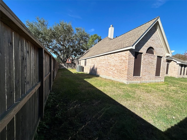 view of side of home with cooling unit and a lawn