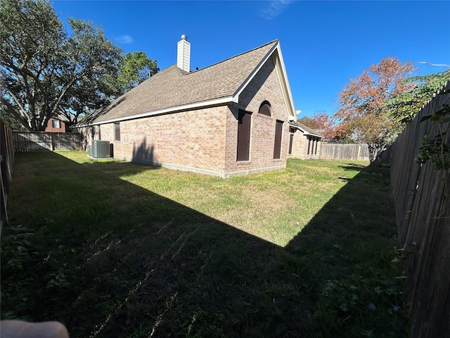 view of side of property with cooling unit and a yard