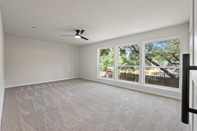 carpeted spare room featuring ceiling fan