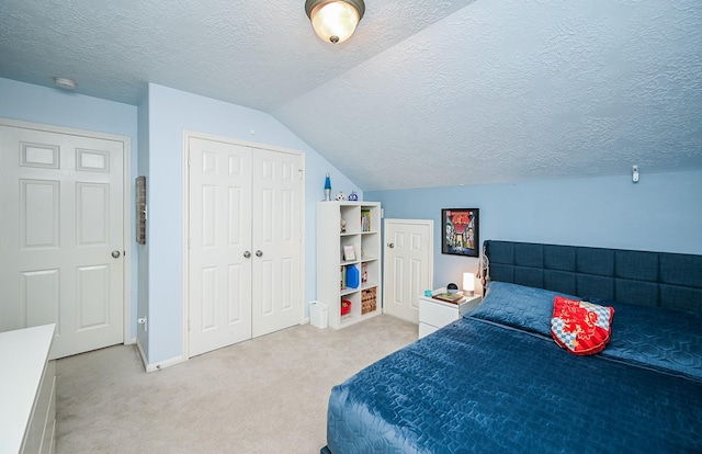 carpeted bedroom with a closet, a textured ceiling, and vaulted ceiling