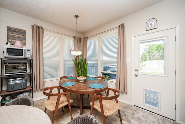 carpeted dining room with a notable chandelier