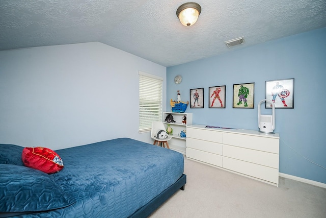 carpeted bedroom featuring a textured ceiling and vaulted ceiling