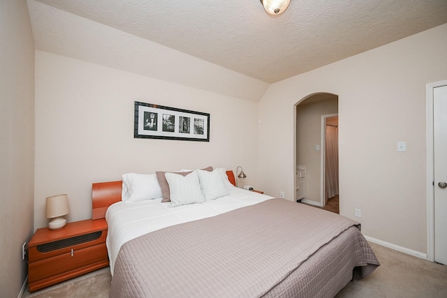 carpeted bedroom with lofted ceiling and a textured ceiling