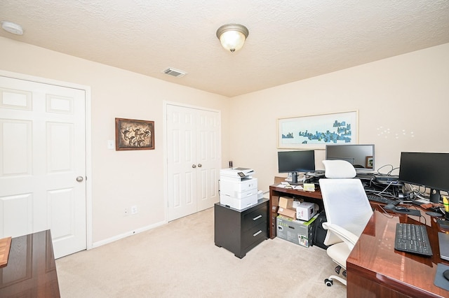 office space featuring light colored carpet and a textured ceiling