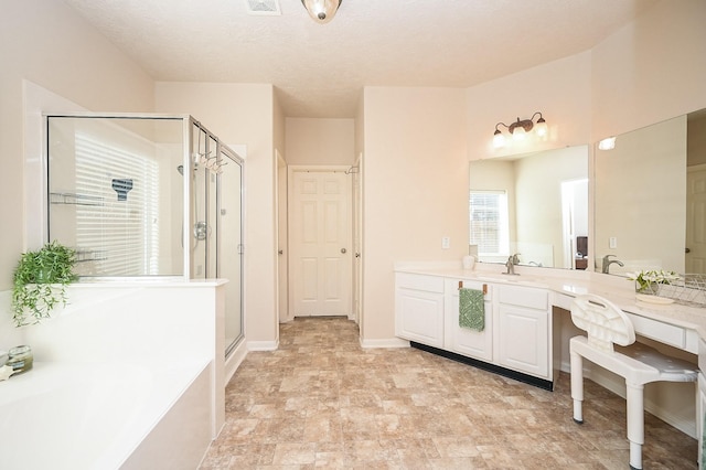 bathroom with a textured ceiling, vanity, and independent shower and bath