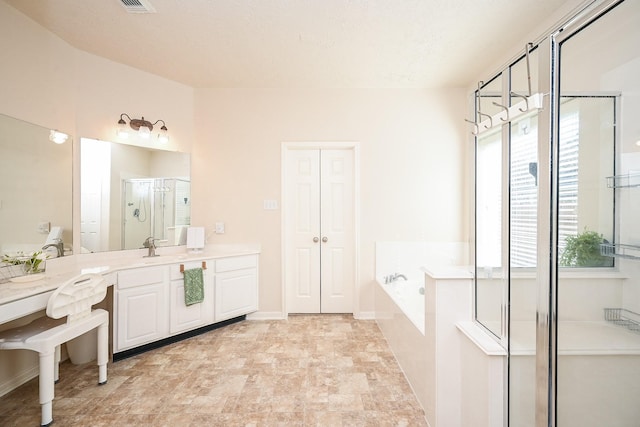 bathroom featuring vanity and independent shower and bath