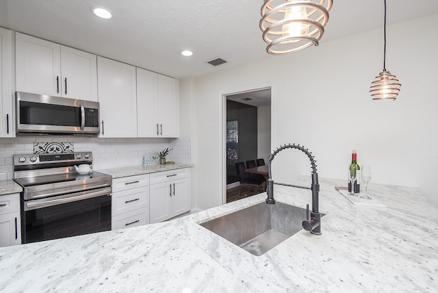 kitchen with sink, white cabinets, and appliances with stainless steel finishes