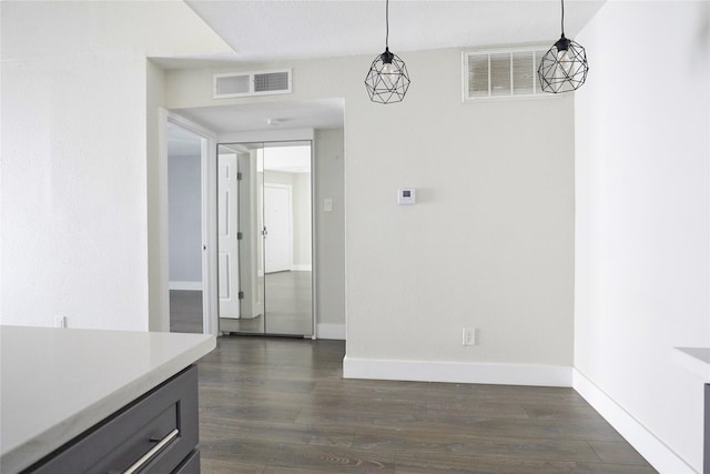 unfurnished dining area featuring dark wood-type flooring