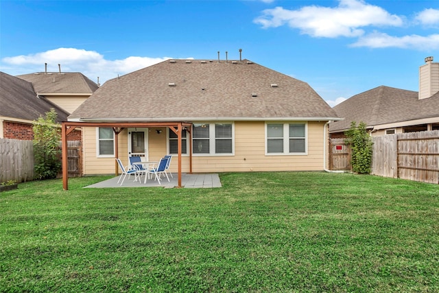 rear view of house with a lawn and a patio