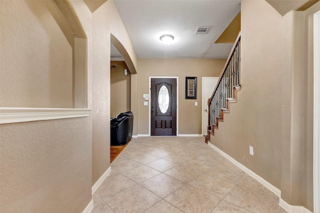 tiled entrance foyer featuring a textured ceiling