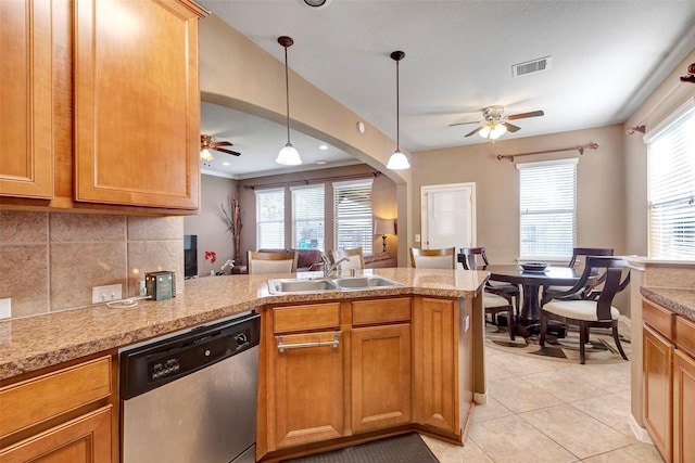 kitchen with decorative backsplash, stainless steel dishwasher, sink, decorative light fixtures, and light tile patterned flooring