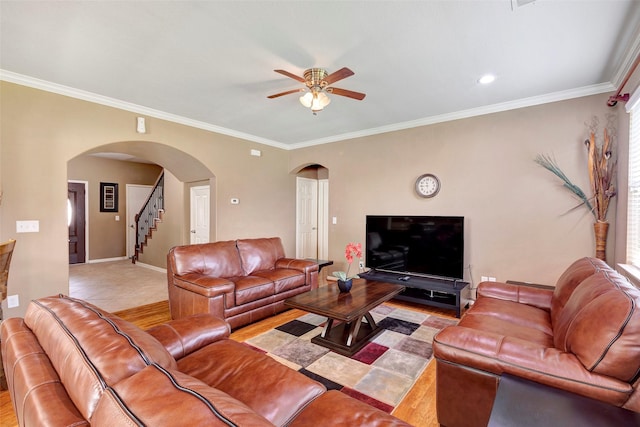 tiled living room with ceiling fan and ornamental molding