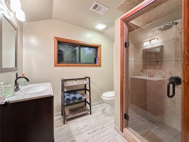 bathroom with vanity, vaulted ceiling, toilet, an enclosed shower, and wood-type flooring