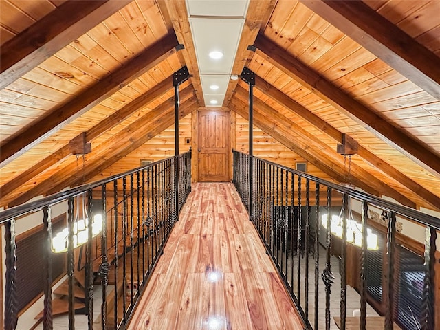 hallway featuring wood ceiling, wood walls, hardwood / wood-style floors, and lofted ceiling with beams