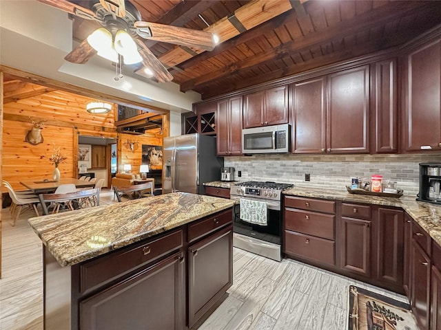 kitchen with appliances with stainless steel finishes, light stone counters, wood ceiling, wooden walls, and beam ceiling