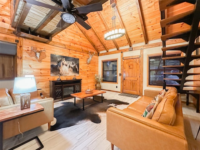 living room featuring ceiling fan, wooden walls, beam ceiling, wooden ceiling, and a fireplace