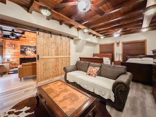 bedroom featuring wooden walls, a barn door, hardwood / wood-style flooring, wooden ceiling, and beamed ceiling