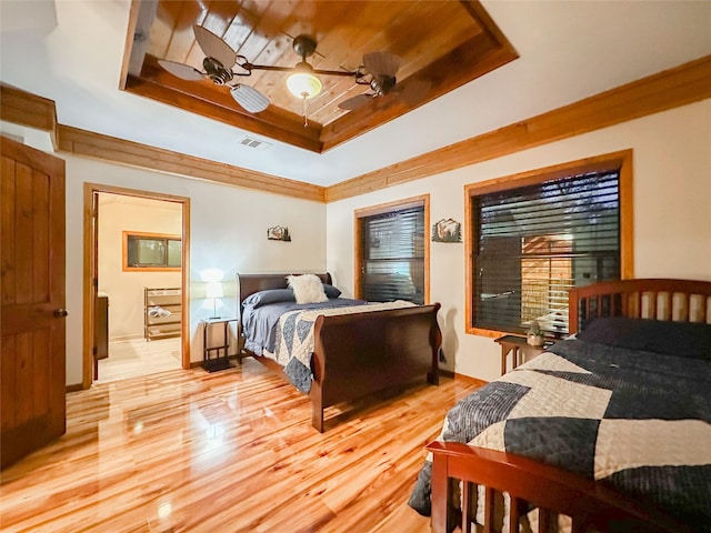 bedroom with ceiling fan, a raised ceiling, and light wood-type flooring