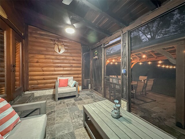 sunroom / solarium featuring lofted ceiling with beams