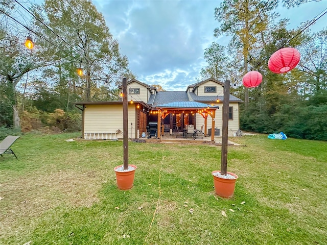 rear view of house featuring a yard and a patio