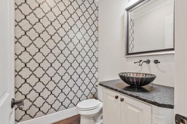 bathroom with hardwood / wood-style floors, vanity, and toilet