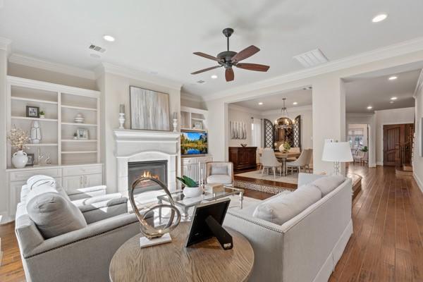 living room featuring wood-type flooring and ornamental molding