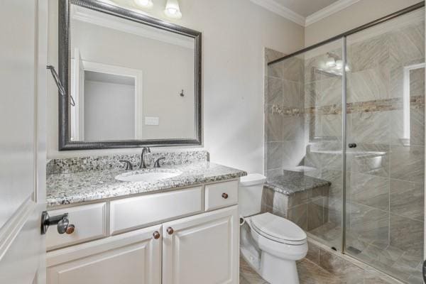 bathroom featuring vanity, toilet, ornamental molding, and walk in shower