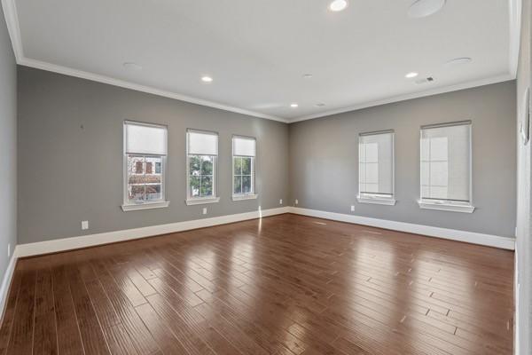 unfurnished room featuring crown molding and dark wood-type flooring