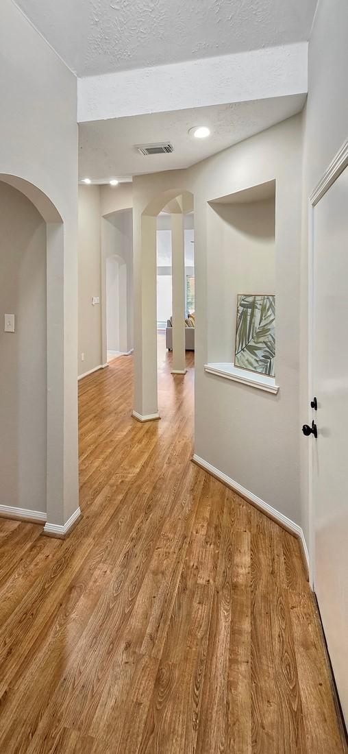 empty room featuring a textured ceiling and light hardwood / wood-style flooring