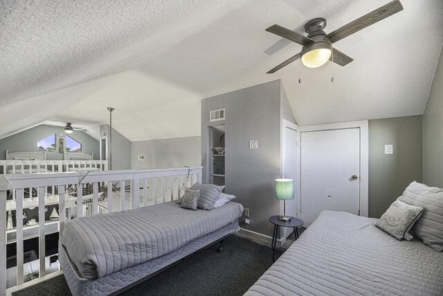 bedroom featuring lofted ceiling, ceiling fan, carpet flooring, and a textured ceiling