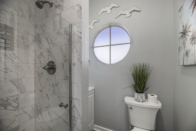 bathroom with a tile shower and toilet