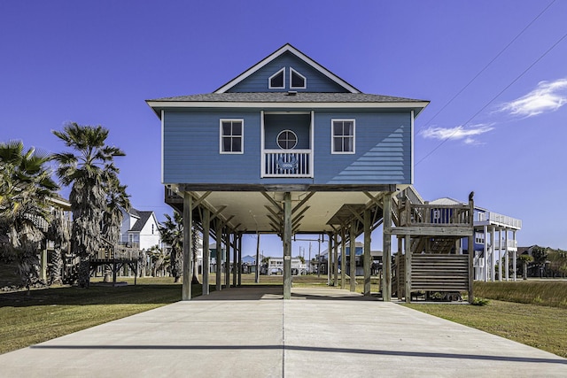 raised beach house with a front yard and a carport