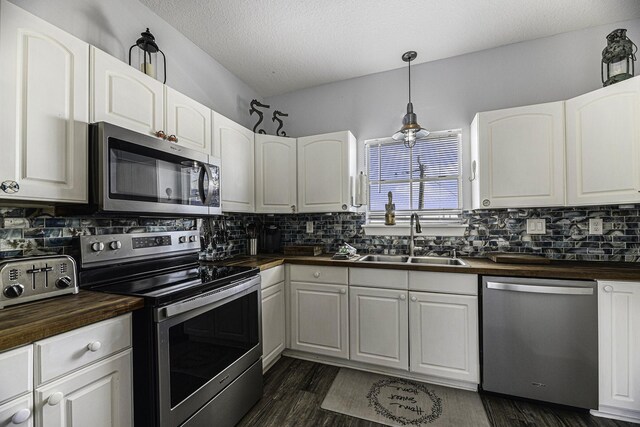 kitchen featuring butcher block countertops, sink, white cabinets, and appliances with stainless steel finishes