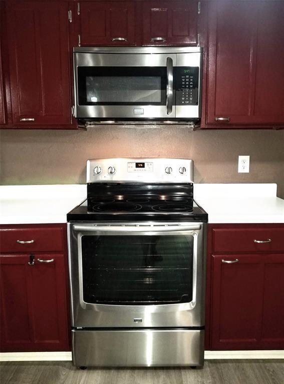 kitchen featuring appliances with stainless steel finishes and dark hardwood / wood-style floors