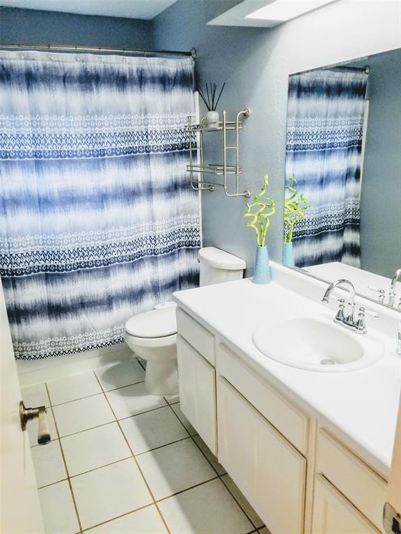 bathroom with tile patterned flooring, vanity, and toilet