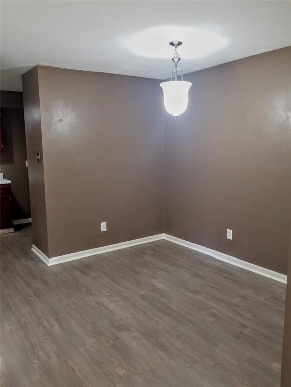 unfurnished dining area featuring dark wood-type flooring