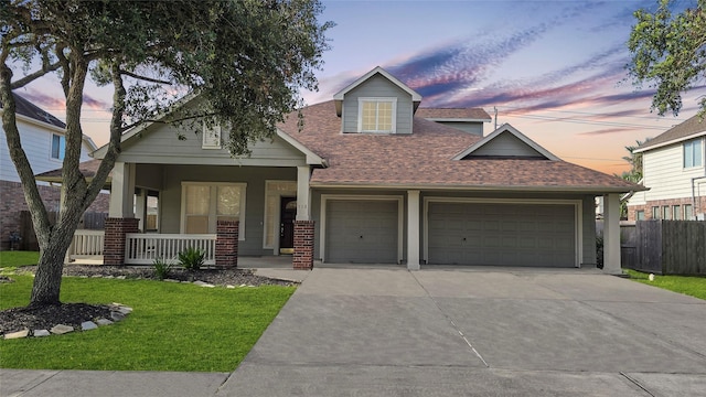 view of front of house with a lawn, a porch, and a garage