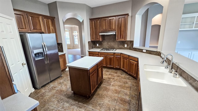 kitchen with decorative backsplash, sink, a center island, and appliances with stainless steel finishes