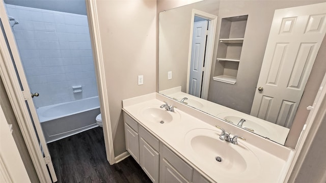 full bathroom featuring built in features, hardwood / wood-style floors, toilet, shower / tub combination, and vanity