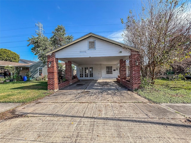 view of front of property with brick siding, an attached carport, concrete driveway, and a front yard