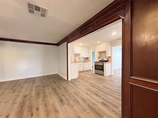 unfurnished living room with ornamental molding and light hardwood / wood-style flooring