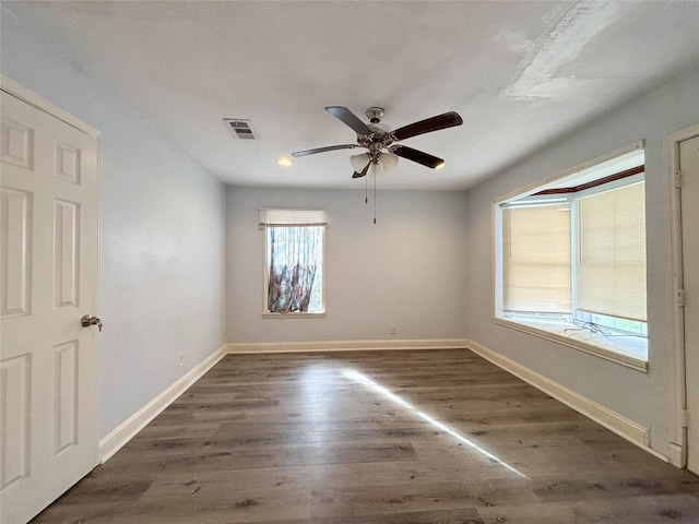 spare room featuring ceiling fan and dark wood-type flooring